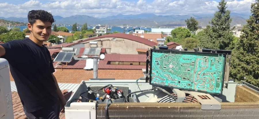 An open outdoor AC unit and circuit board with a member of our service team