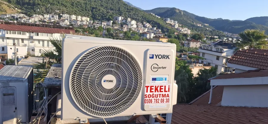 Tekeli Soğutma etiketli dış ünite ve arkasında yerleşim manzarası